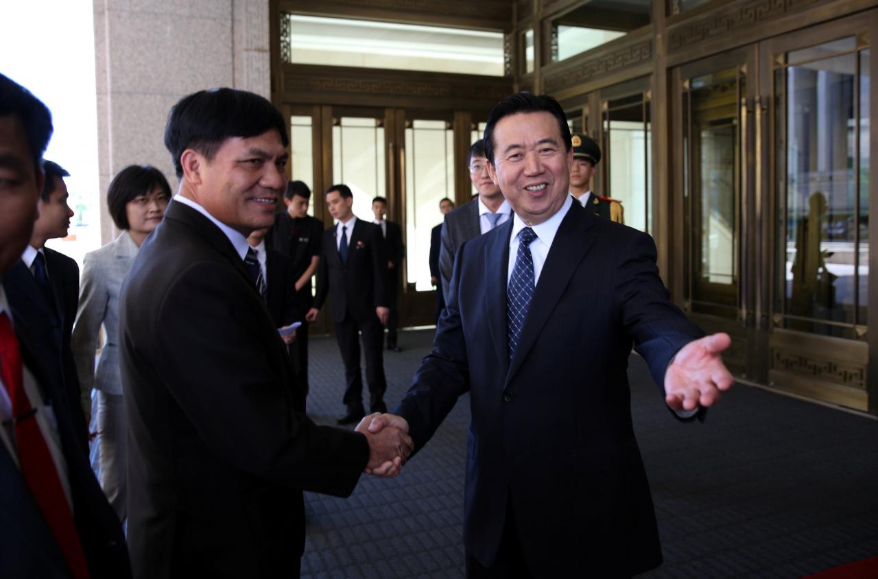 Meng Hongwei, Chinese Vice Public Security Minister, shakes hands with Nguyen Quang Dam, the commandant of the Vietnam Coast Guard, in Beijing